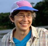 Nancy, wearing a cap, smiling